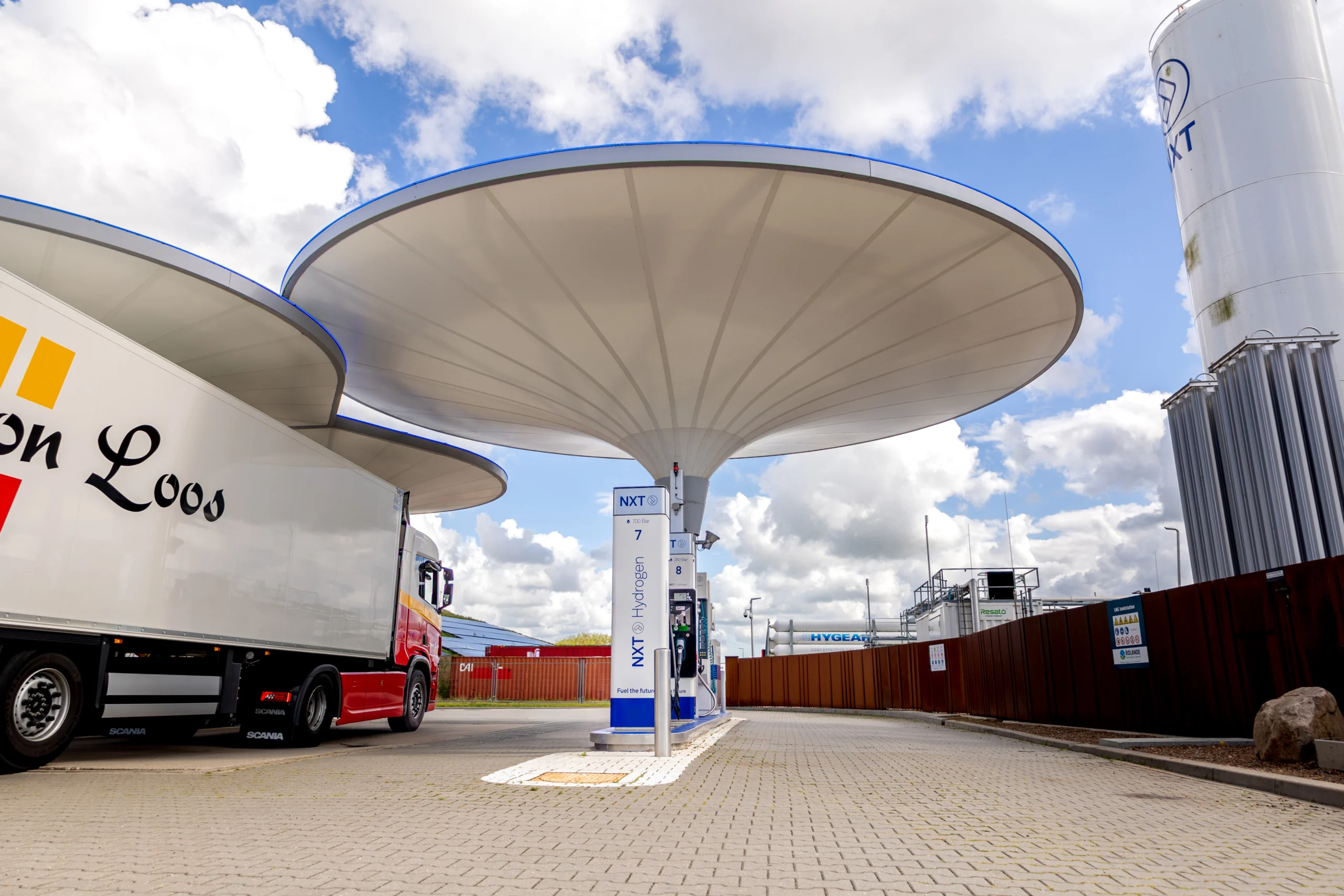 Waterstoftankstation op een bedrijventerrein met vrachtwagen van Simon Loos onder een futuristische canopy, gericht op duurzame logistiek
